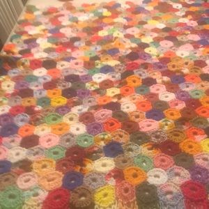 Vintage hand crocheted small afghan with fringe detail.